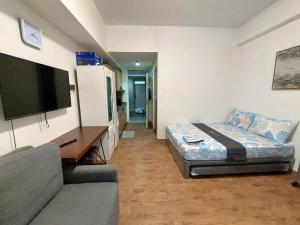 a living room with a couch and a flat screen tv at ANIA CONDO STAY in Mactan