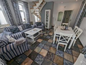 ein Wohnzimmer mit einem Sofa und einem Tisch in der Unterkunft Dat Fischerhus - Horumersiel in Wangerland