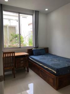 een slaapkamer met een bed, een tafel en een raam bij The Greenery in Phnom Penh
