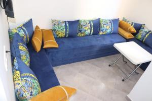 a blue couch with pillows and a table in a room at Taghazout Flats in Taghazout