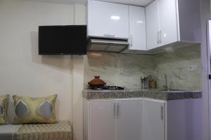 a kitchen with white cabinets and a counter top at Taghazout Flats in Taghazout