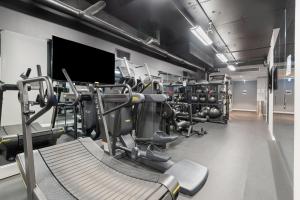 een fitnessruimte met verschillende loopvlakken en een simulator bij Chic 2-Bed by Natural Trails with Pool & BBQ in Melbourne