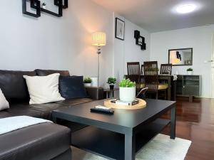 a living room with a couch and a table at Spacious 53 SQM - BTS Thong Lo - Ultra Fast WiFi in Khlong Toei