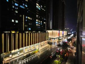 een stadsstraat 's nachts met gebouwen en auto's bij Deluxe 1br - Bgc Uptown - Netflix, Pool #oursw7b2 in Manilla