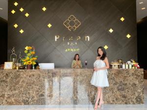a woman in a white dress standing in front of a counter at Divalux Resort & Spa Bangkok, Suvarnabhumi Airport-Free Shuttle in Lat Krabang