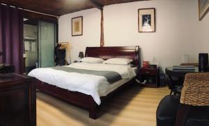 a bedroom with a large bed and a table at Lijiang Jayden Lodge臣安山居民宿 - Namaste in Lijiang