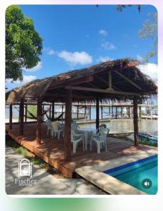 un pabellón con mesa y sillas junto a una piscina en Eco Hotel Fischer LTDA, en Engenho Araci