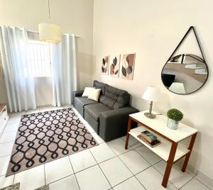 ein Wohnzimmer mit einem Sofa und einem Spiegel in der Unterkunft Casa Ampla - Ótima Localização in Piracicaba