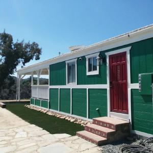 a green and red house with a red door at Mystic Mountain Retreat in Miramonte
