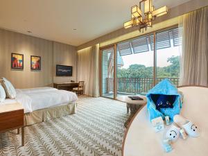 シンガポールにあるResorts World Sentosa - Equarius Hotelのベッドと大きな窓が備わるホテルルームです。