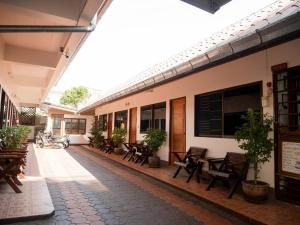 a courtyard of a building with chairs and tables at Orchid house in Chiang Rai