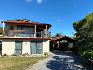 uma casa grande com uma varanda e uma entrada em Pohara Tides - Poharas Beach Getaway em Pohara