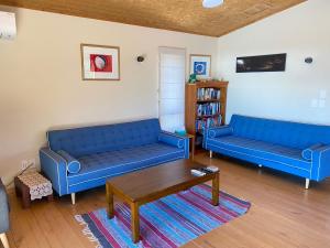 uma sala de estar com dois sofás azuis e uma mesa de centro em Pohara Tides - Poharas Beach Getaway em Pohara