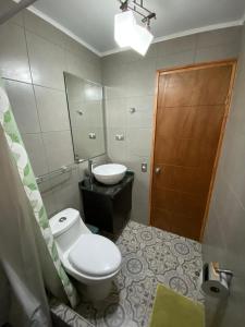 uma casa de banho com um WC, um lavatório e um espelho. em Casa veraneo Consistorial El Tabo Chile em El Tabo