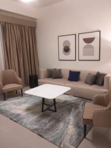 Address marassi resort في العلمين: غرفة معيشة مع أريكة وطاولة وكراسي