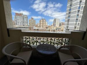 a balcony with a table and chairs and a view of a city at Charming Downtown Apartment in Alexandria