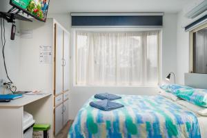 una camera ospedaliera con un letto e una finestra di Emu Bay Holiday Homes a Emu Bay