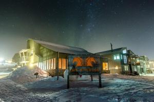 un edificio con un cartel en la nieve por la noche en Courtyard Loft 12 The Stables Perisher en Perisher Valley