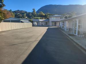 una strada vuota con una montagna sullo sfondo di Ferrylink Motel a Picton