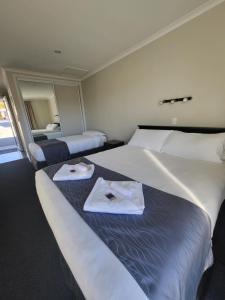 Dos camas en una habitación con toallas. en Ferrylink Motel en Picton