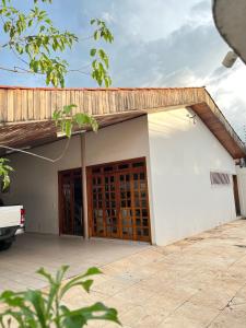 ein kleines weißes Gebäude mit Holztüren darauf in der Unterkunft Ampla Casa Duplex com 4 suítes in Teresina