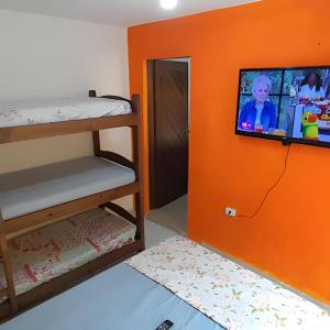 Habitación con litera y TV en la pared. en Hostel Sorocabana Beach, en Itanhaém 14 fotos más