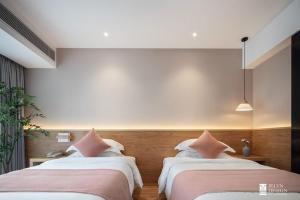 um quarto com 2 camas e almofadas cor-de-rosa em ComFo inn em Sītāmarhi