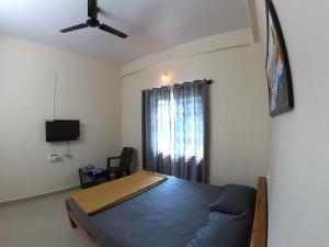 齊齊曼卡羅的住宿－happy holiday Inn service apartment，一间卧室配有一张床和吊扇