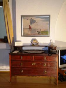 a wooden dresser with a clock on top of it at Casa Rozelor in Braşov
