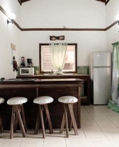 a kitchen with a counter with stools and a refrigerator at Corrales House in Tela