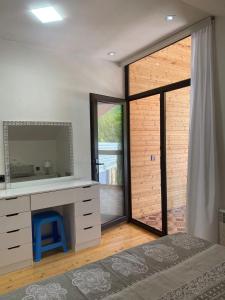 1 dormitorio con tocador con espejo y ventana en Sheki Guest Villa, en Sheki