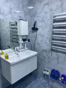a white bathroom with a sink and a shower at Sheki Guest Villa in Sheki