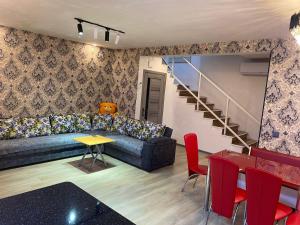 - un salon avec un canapé, une table et des chaises dans l'établissement Sheki Guest Villa, à Shaki