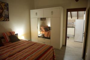 a bedroom with a bed and a closet with a mirror at Villa Caraibe in Petit-Canal