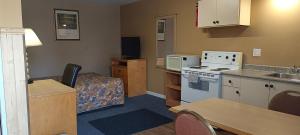 a small room with a kitchen and a living room at Gold Pan Motel in Quesnel