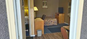 een kamer met een slaapkamer met een bed en een tafel bij Gold Pan Motel in Quesnel