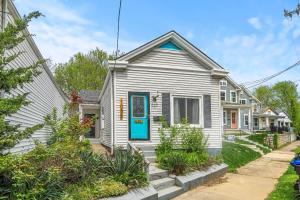 een wit huis met een blauwe deur op een straat bij Cozy Home Gateway to City Exploration in Louisville