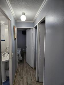 a hallway of a bathroom with a sink and a toilet at Departamento Puertas del Mar in La Serena