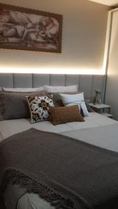 a bedroom with a large white bed with pillows at Apartamento em Canela perto da Catedral - Catedralle in Canela
