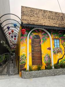 a yellow building with a door and flowers on it at Phố Cổ Homestay in Kỳ Vĩ +40 photos