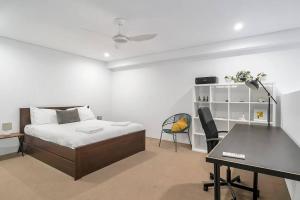 Schlafzimmer mit einem Bett, einem Schreibtisch und einem Tisch in der Unterkunft 'The Abstract at Kingsford' Spacious and Sunny Stay in Sydney