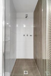 ein Bad mit einer Dusche und einer Glastür in der Unterkunft 'The Abstract at Kingsford' Spacious and Sunny Stay in Sydney