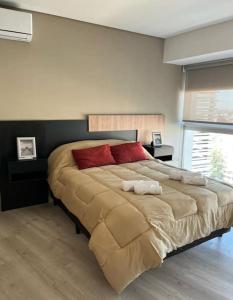 - une chambre avec un grand lit et des oreillers rouges dans l'établissement Torre Golden 8Pax By Inside, à Mendoza