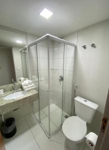 ein Bad mit einer Dusche, einem WC und einem Waschbecken in der Unterkunft It's Hotel in Caratinga