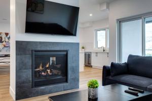 a living room with a fireplace with a tv above it at Luxury Golf Stay w/Hot Tub in Kelowna