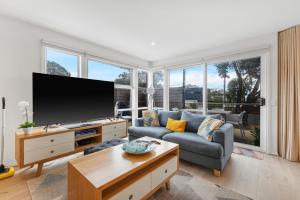 カウズにあるThe Seaside Havenのソファと薄型テレビのあるリビングルーム