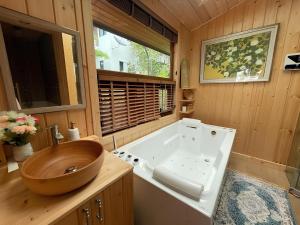 y baño con bañera de madera y lavabo de madera. en Bella Vista Khao yai en Ban Muak Lek Nai