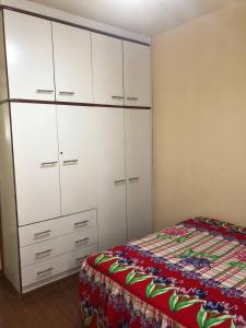 a bedroom with a bed and white cabinets at Quarto em Alphaville Barueri SP in Barueri
