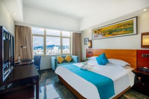 a hotel room with a bed and a television at Shengyi Holiday Villa Hotel in Sanya