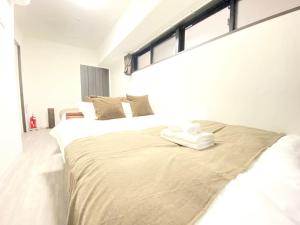 um quarto com uma cama com duas toalhas em アネックス日本橋東201 em Osaka